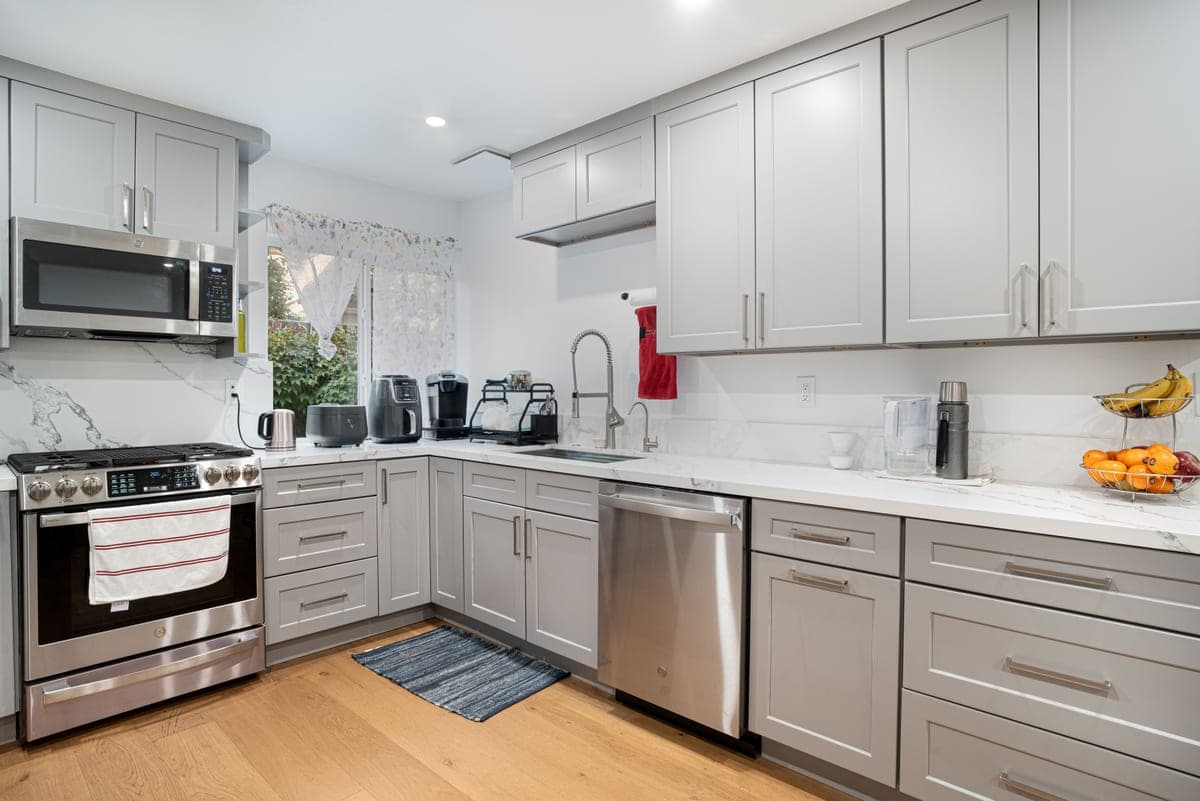 Kitchen with gray cabinets and a 13 gallon trash can