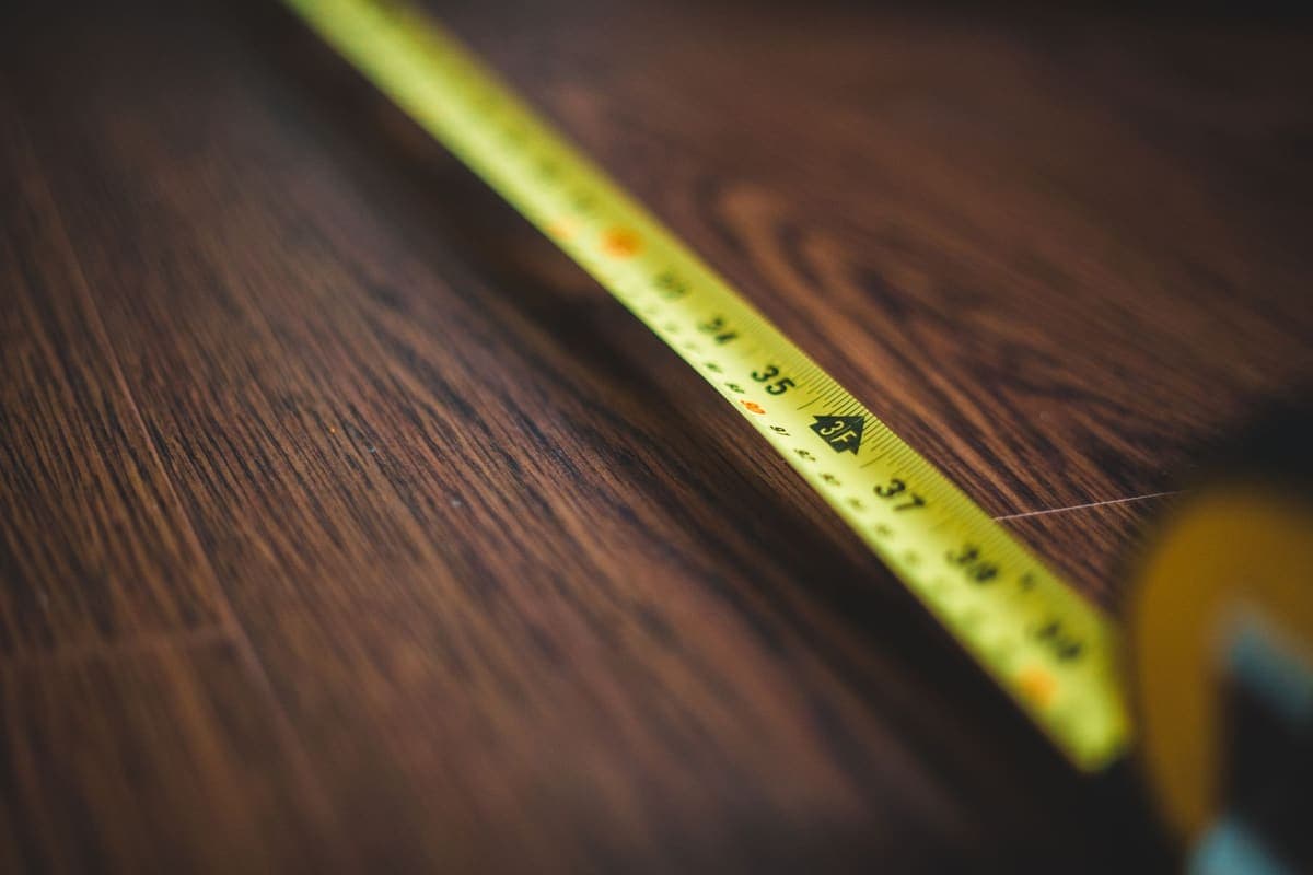 Tape measure on a floor beside a kitchen cabinet