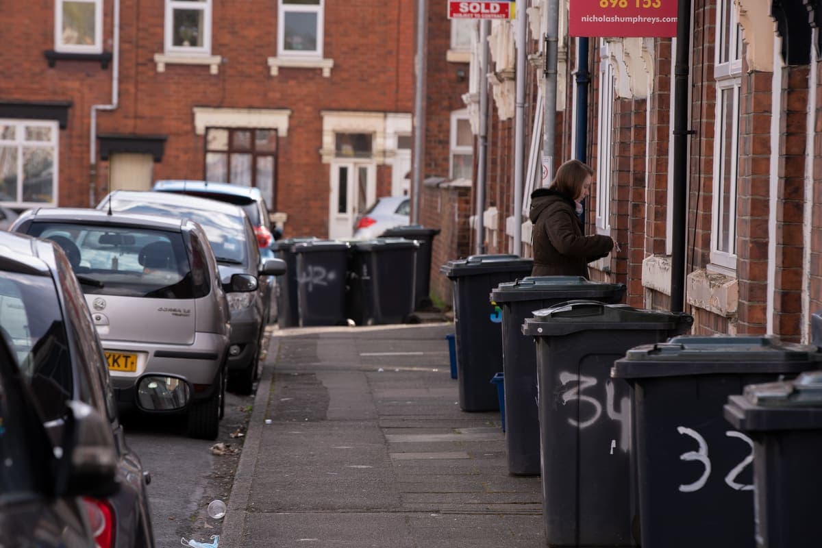 Household trash cans standing outside a house