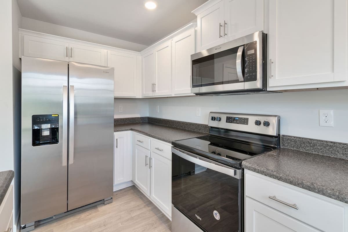 A kitchen with white cabinets and stainless steel appliances