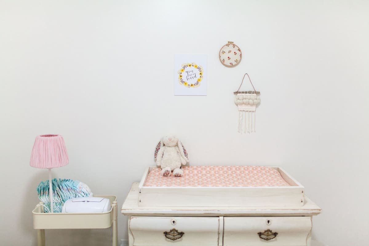 Nursery changing table with folded diapers in a basket
