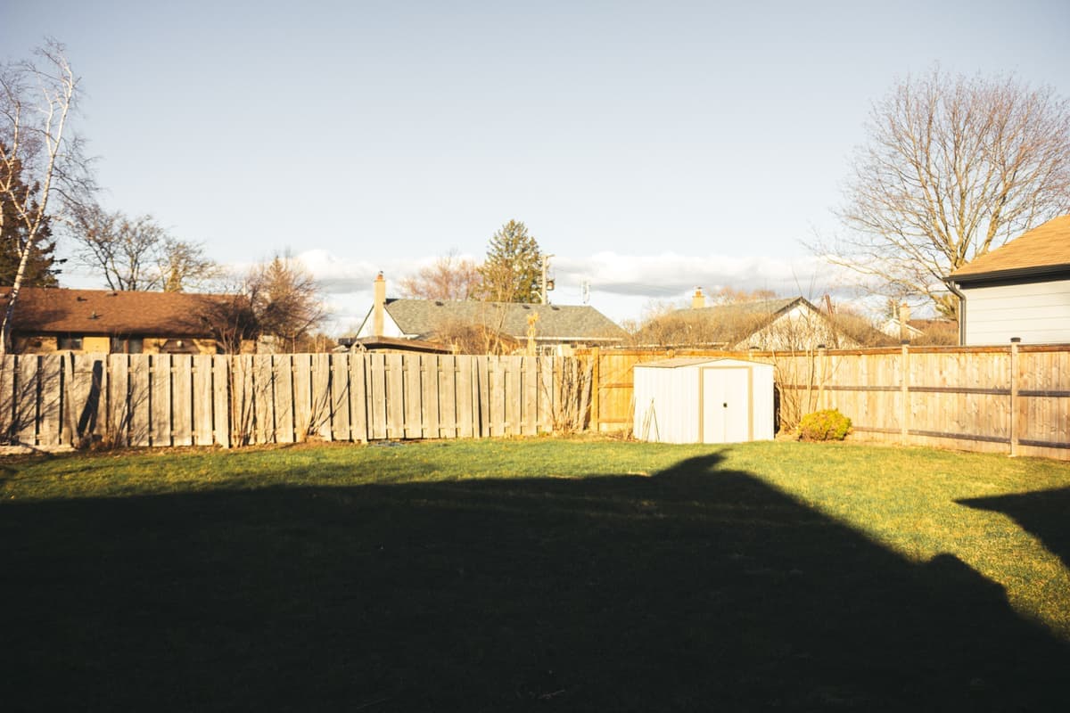Garden storage unit beside a fence