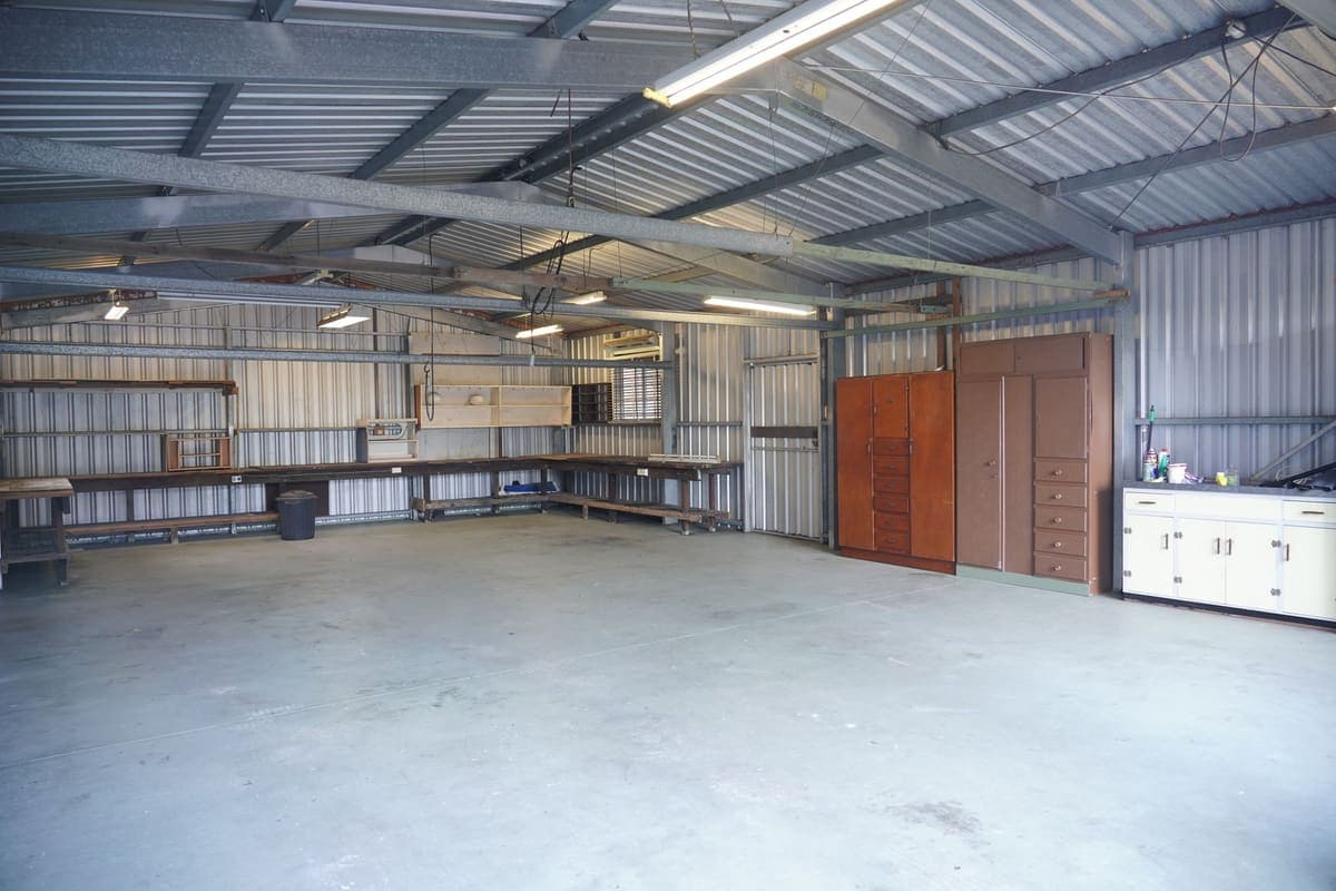 Tidy garage workshop with a bin beside the workbench