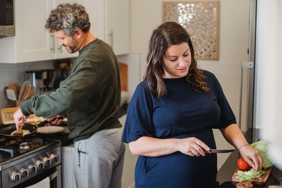 Family preparing food together in a busy home kitchen
