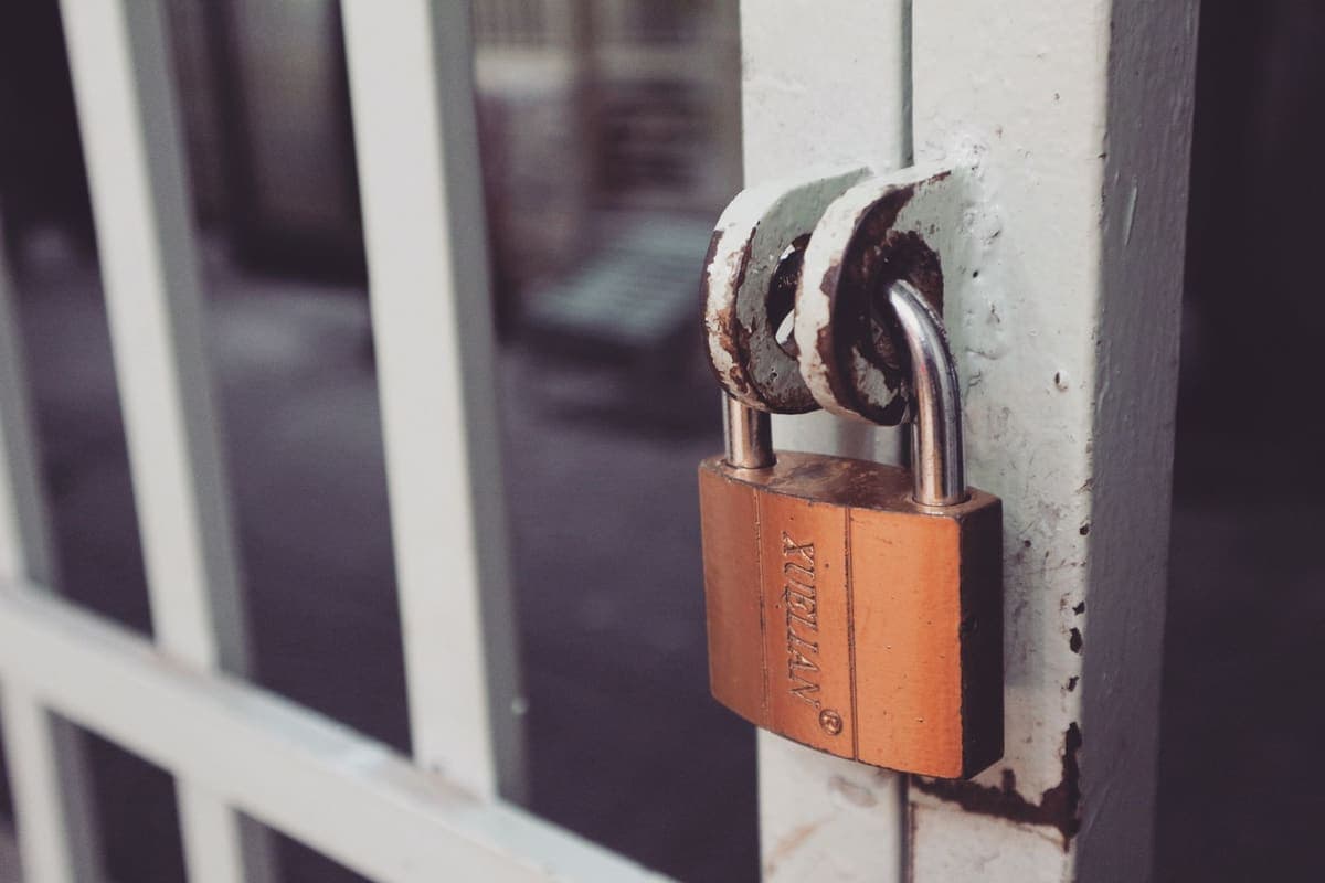 Close-up of a brass padlock on a gate latch