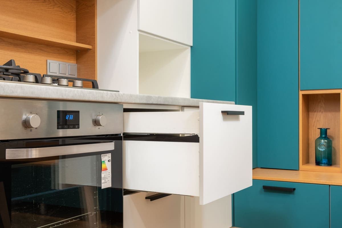 An open drawer in a modern kitchen cabinet run