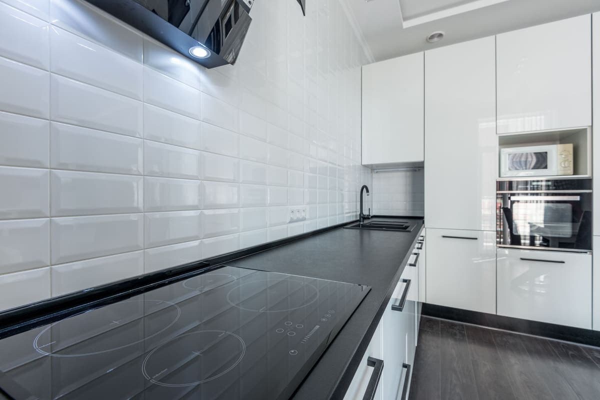 A kitchen with a hard floor and a run of cabinets