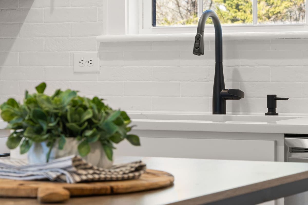 Modern white kitchen counter with a black faucet