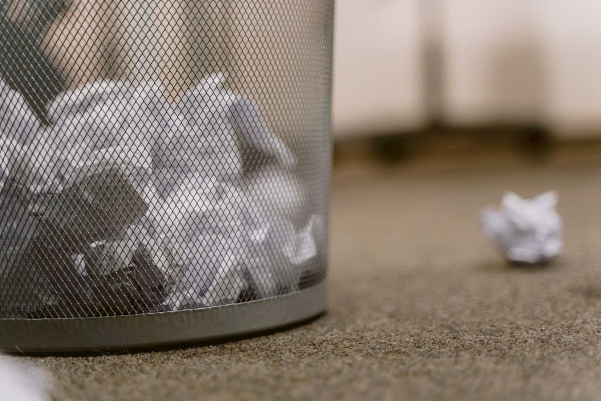 Plastic wastebasket holding crumpled paper