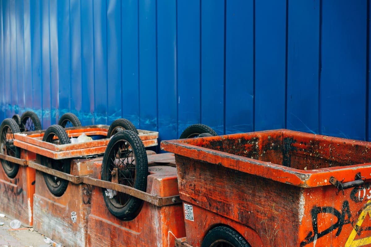 Two-wheeled waste carts standing outside a building