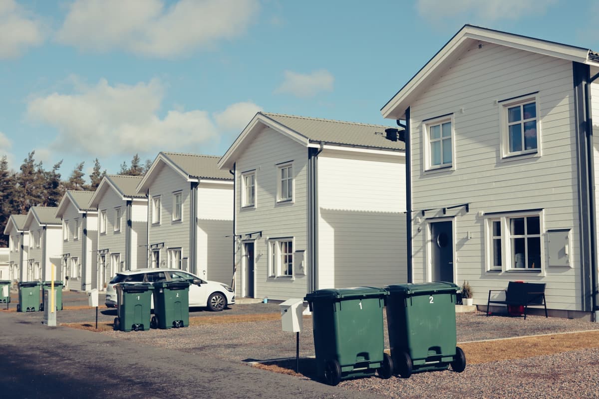 Wheeled waste cart being moved down a driveway